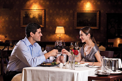 couple dining together while touching wine glasses